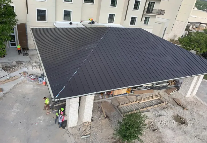Metal roofing installation team working on a commercial building in Greece